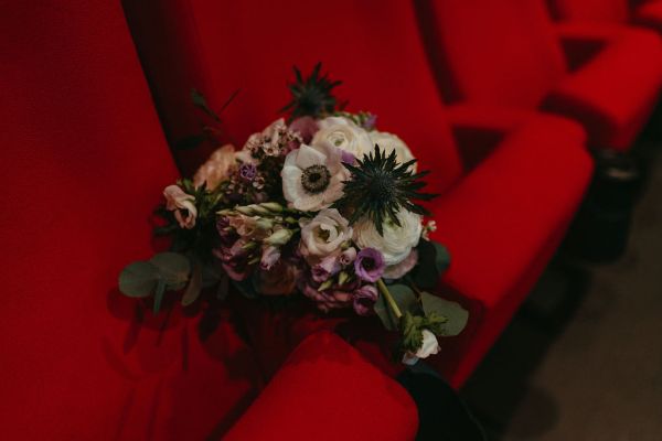 Bouquet is placed on red seat in cinema