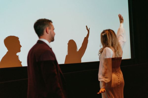 Bride and groom reflection on white cinema screen