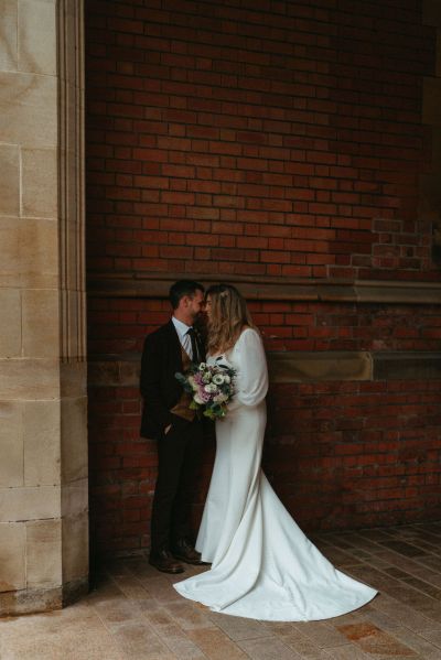 Bride and groom kiss under archway