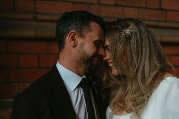 Bride and groom place foreheads together and smile