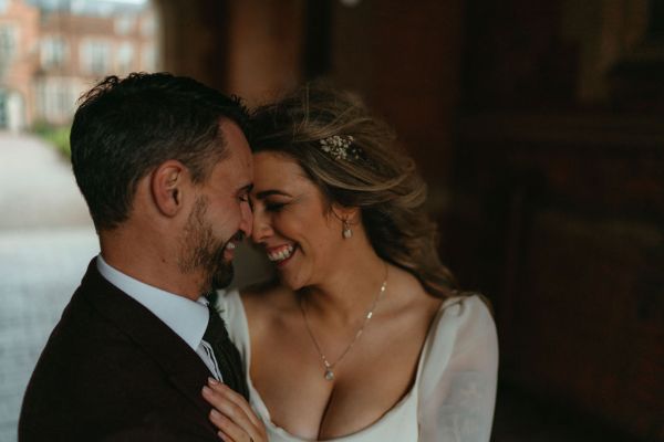 Bride and groom laughing heads touching hugging