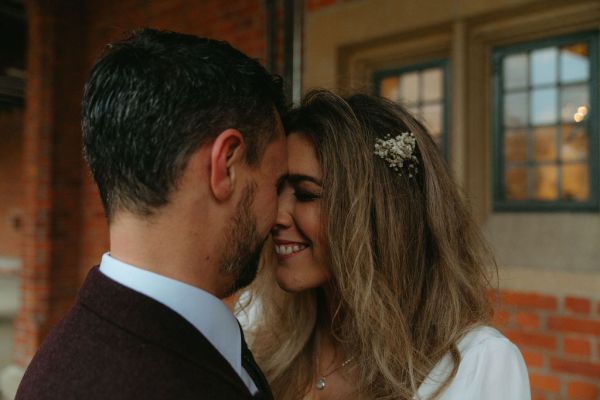 Bride and groom go in for a kiss they touch foreheads