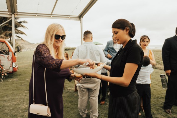 Guests taking finger food from waitress