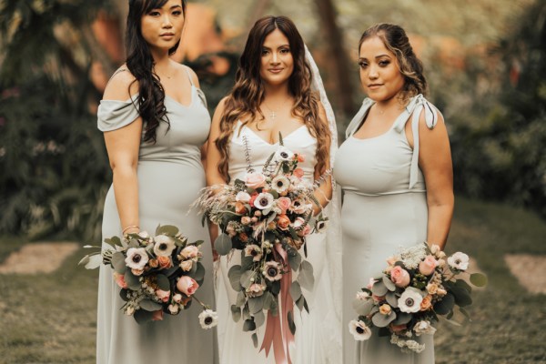 Bride and her bridesmaids standing with bouquet/flowers