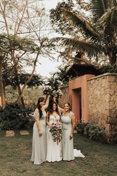 Bride and her bridesmaids standing with bouquet/flowers garden setting