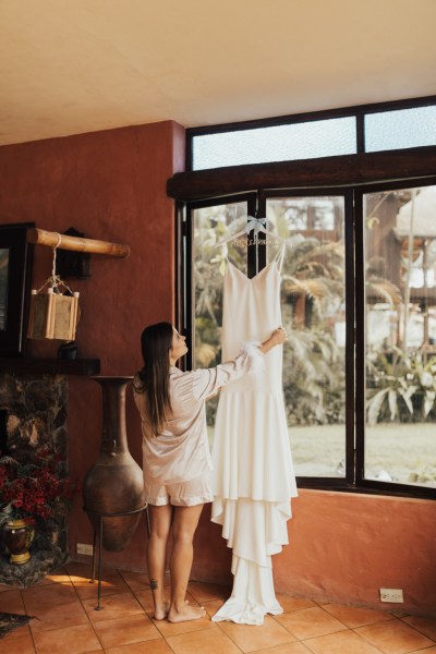 Bride taking down her bridal wedding gown dress