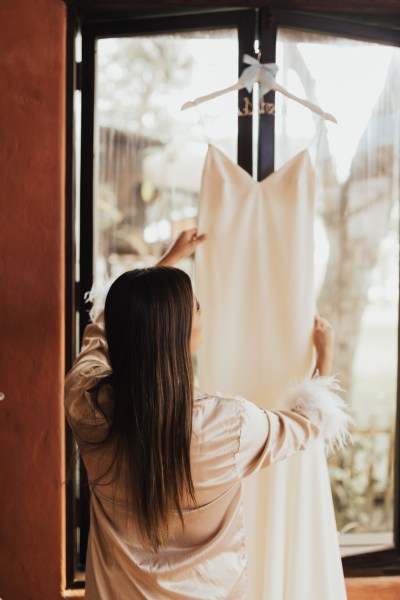 Bride taking down her bridal wedding gown dress