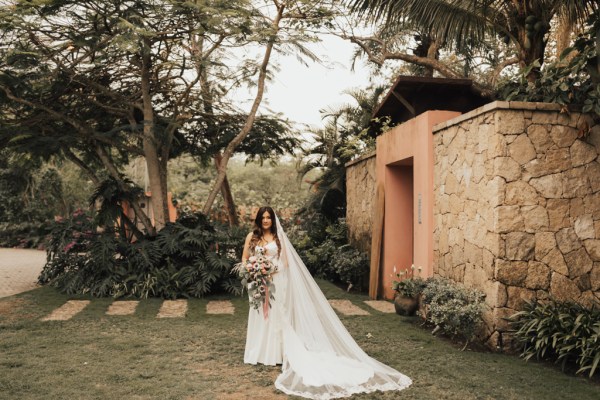 Bride standing in garden holding bouquet