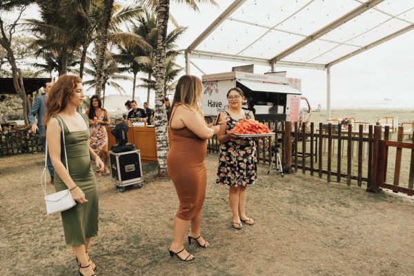 Guests in courtyard holding plate of watermelon