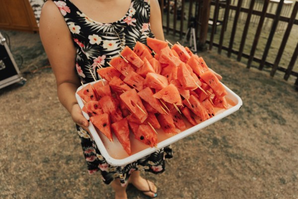 Guest in courtyard holding plate of watermelon