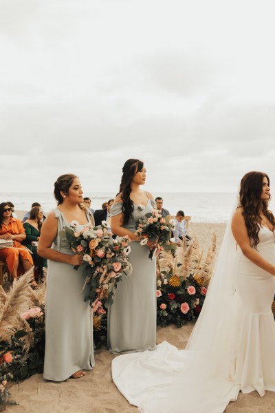 Bride and two bridesmaids at alter setting