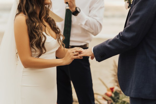 Bride and groom exchanging rings with celebrant