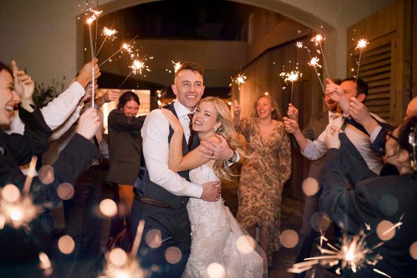 bride and groom sparklers dancefloor smiling laughing guests