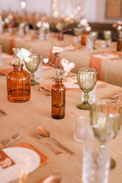 Table setting cutlery orange plates gold spoon flowers and lights