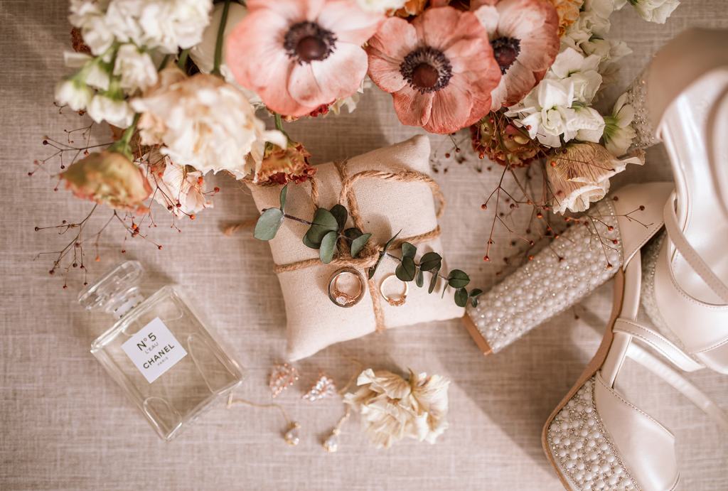 Cushion wrapped in flowers ivy wedding bands/rings and perfume bottle