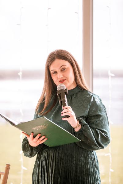 Celebrant wearing green speaks into microphone