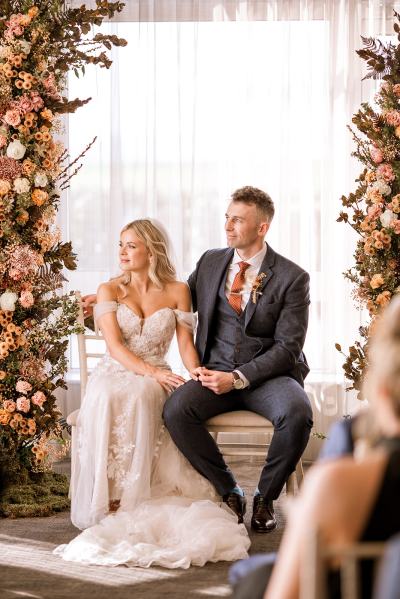 Bride and groom sit at the alter during ceremony