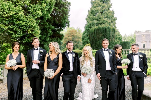 Groom bridesmaids bride and groomsmen pose for a photo