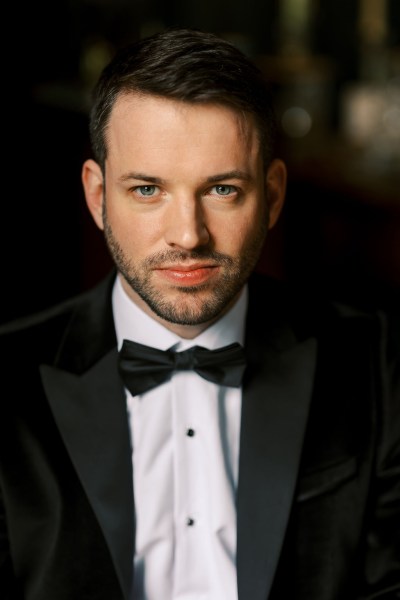 Groom faces camera wearing bowtie shirt and suit