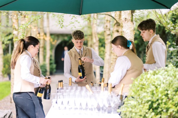 Waiter serves pours champagne into glasses