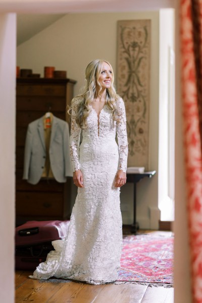 Bride stands ready looking out of window