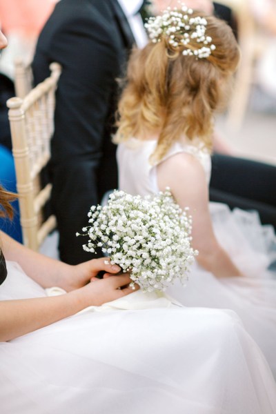 Close up of little girls white dress and bouquet