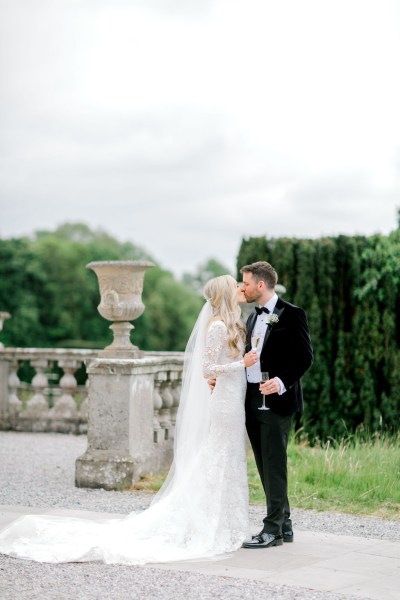 Bride and groom face each other holding hands