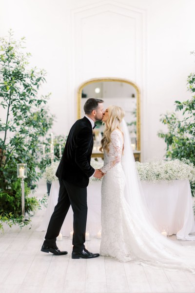 Groom kisses bride holding hands