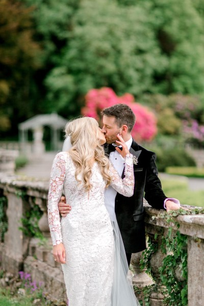 Bride kisses groom over the shoulder