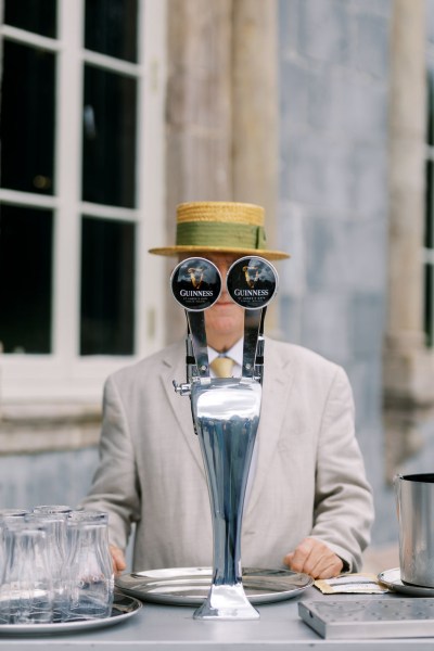 Man standing behind beer keg at bar Guinness