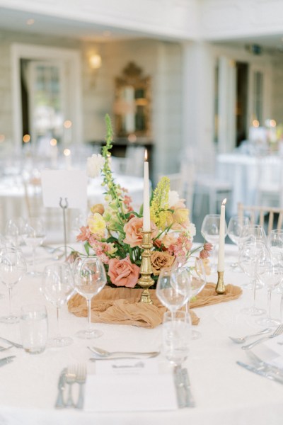 Roses cutlery on table candles lit flowers on white tablecloth