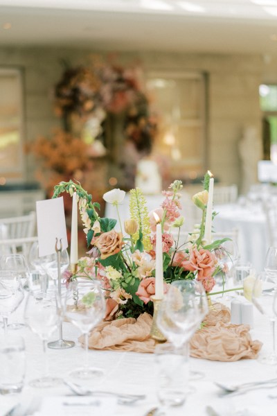 Roses cutlery on table candles lit flowers on white tablecloth