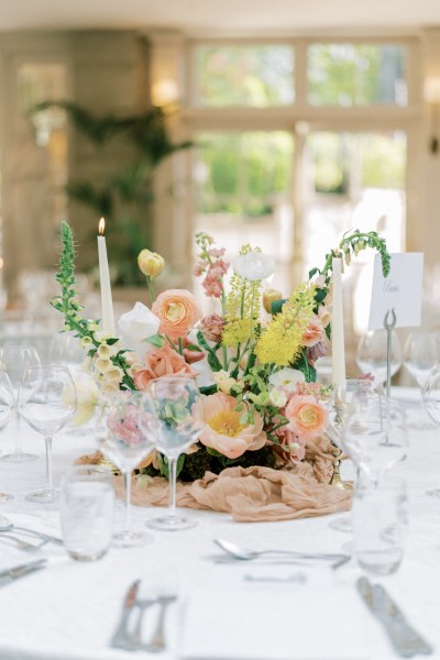 Roses cutlery on table candles lit flowers on white tablecloth