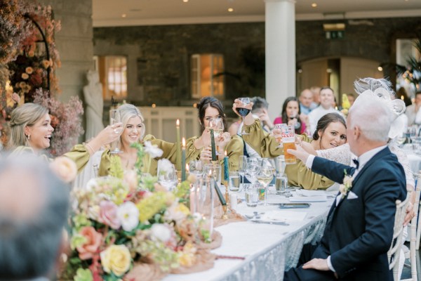 Atmosphere shot of bridesmaids and father at dining room table