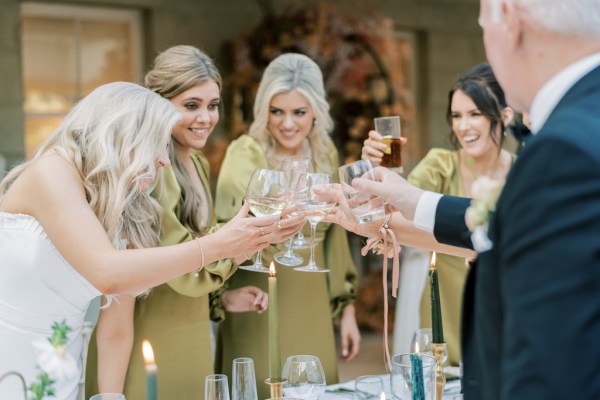 Bridesmaids father and bride cheers with glasses of white wine