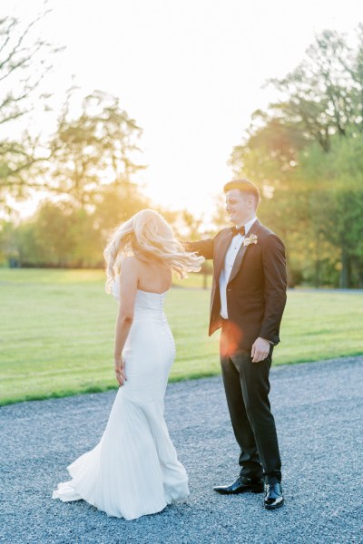 Bride and groom close together grass garden setting they dance