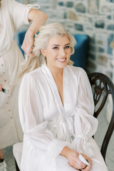 Bride wearing bridalwear getting her hair done