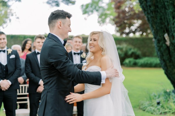 Bride and groom at alter in front of guests during ceremony