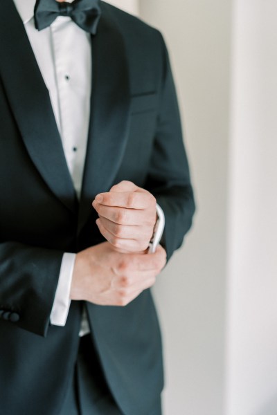 Groom fixes up his cufflinks on shirt