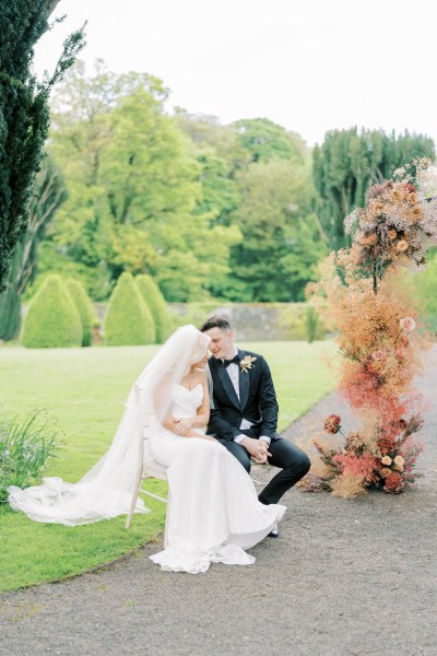 Bride and groom sit on chairs at alter during ceremony