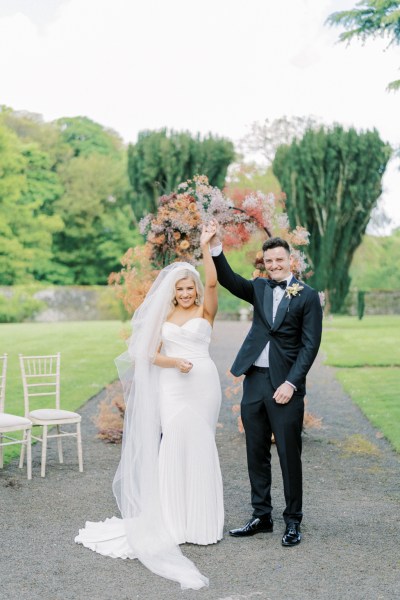 Bride and groom raise their hands at the alter