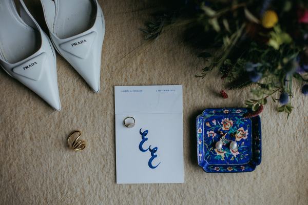 Plate filled with pearl earrings and bridal heels shoes in shot