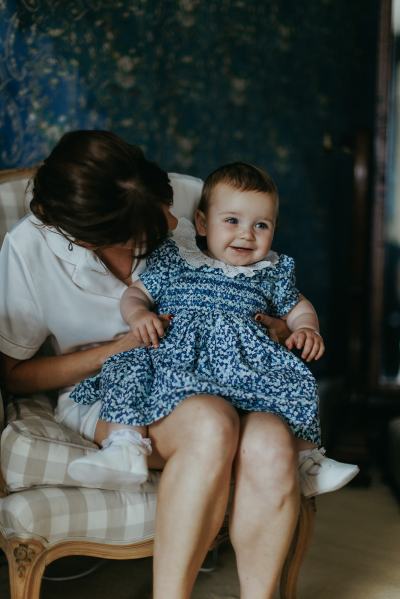 Little baby girl laughing on mother brides lap