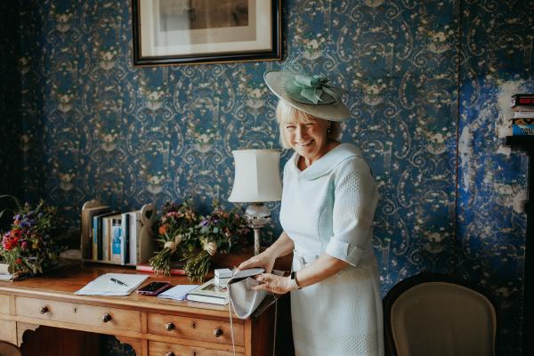 Mother poses and smiles beside table