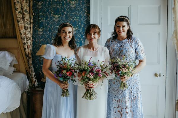 Bride in the middle bridesmaids either side holding bouquet