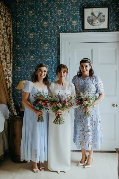 Bride in the middle bridesmaids either side holding bouquet