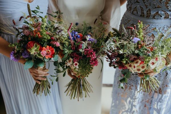 Bride in the middle bridesmaids either side holding bouquet