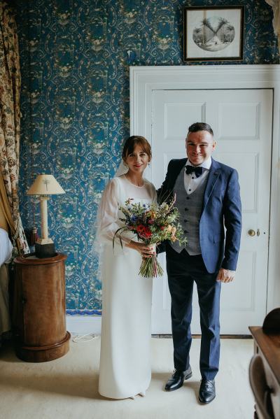 Bride and father pose in room before wedding