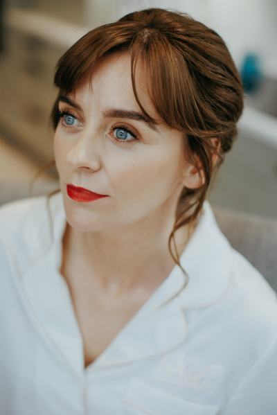 Bride has makeup on red lipstick and hair is done