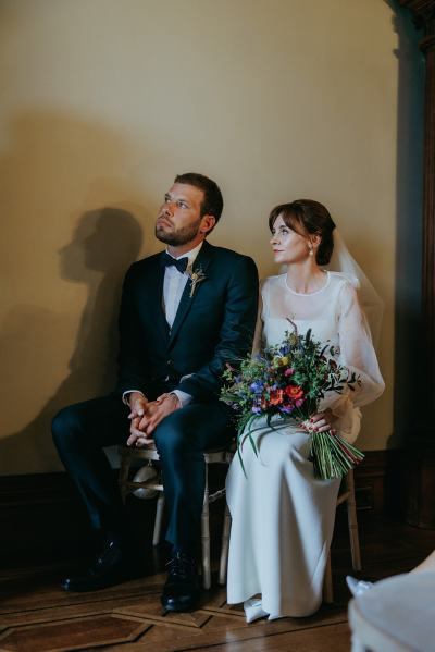 Bride and groom seated at top of alter setting